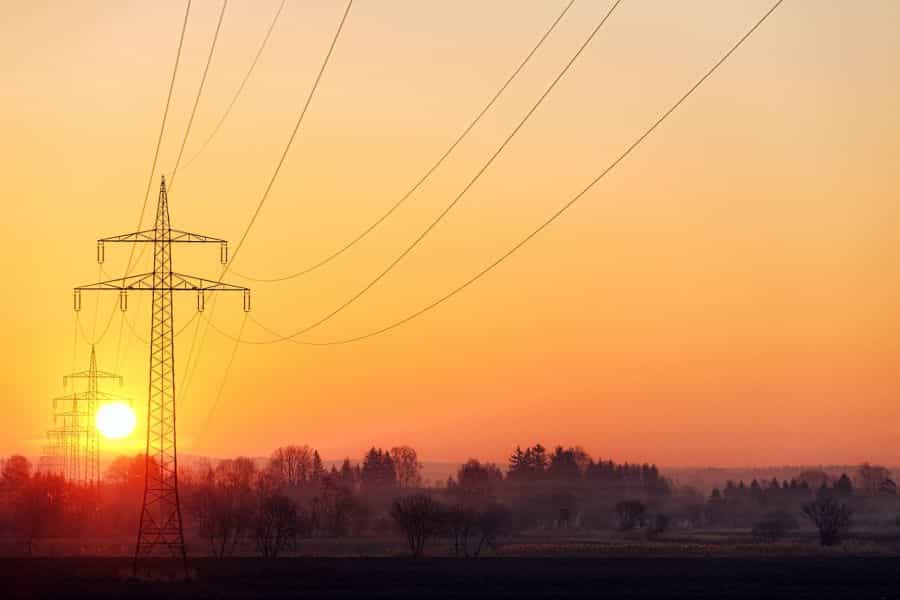 eine Hochspannungsleitung mit auf- oder untergehender Sonne