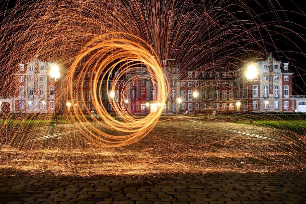 die Westfälische Wilhelms-Universität in Münster, nachts mit einem Feuerrad