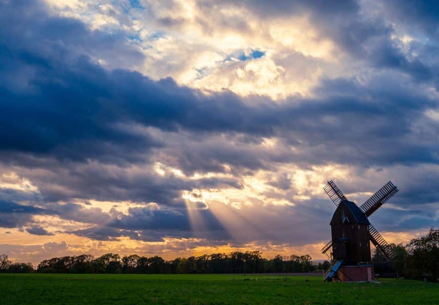 Eine Windmühle vor bewegtem Abendhimmel